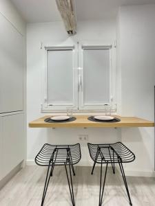 stół z 2 krzesłami i 2 oknami w obiekcie Pequeña suite independiente al lado Burgas w mieście Ourense