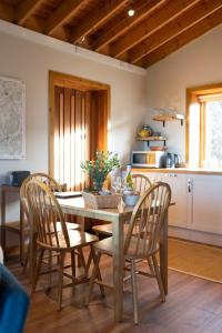 a kitchen with a wooden table and chairs in a room at The Bothy at Coneloch in Elgin
