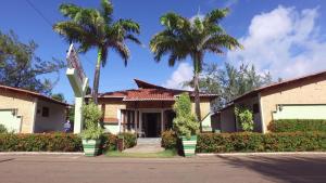 un edificio con dos palmeras delante en Pousada Caribe Sul, en Barra do Cunhau