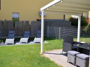 un grupo de sillas bajo un pabellón en un patio en Appartamento Campagnola con giardino privato e due camere da letto, en Riva del Garda