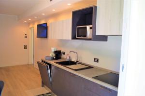 una cucina con lavello e microonde di Appartamento Campagnola con giardino privato e due camere da letto a Riva del Garda