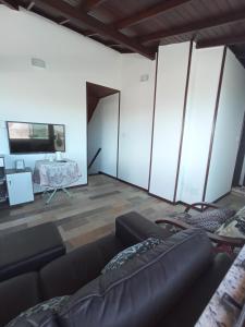 a living room with a couch and a tv at Cobertura em cabo frio in Cabo Frio