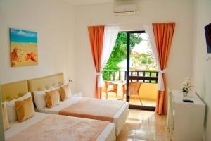 a hotel room with two beds and a balcony at Aparthotel Santa Maria Beach in Santa Maria