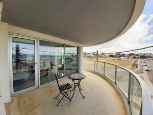 a balcony with a table and chairs on it at Costa Mar in Puerto Madryn