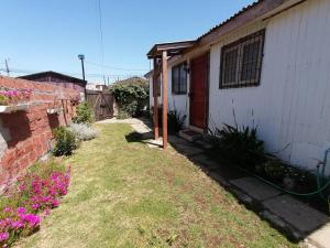un cortile accanto a una casa con fiori rosa di Cabaña "Descanso playero" a Quintero