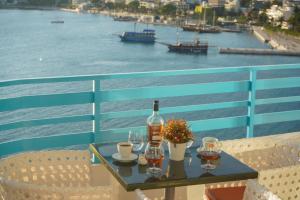 a table with a bottle of wine and two glasses at Apartments Serxhio in Sarandë