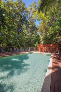 a pool of water with trees and palm trees at Cape Trib Beach House in Cape Tribulation