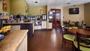 a restaurant with a bar and tables and chairs at Best Western Fairwinds Inn in Cullman