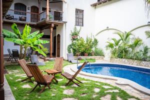 einen Garten mit Stühlen und einem Pool in der Unterkunft Hotel Patio del Malinche in Granada