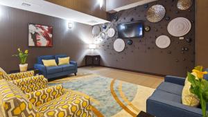 una sala de estar con sofás y una pared con placas. en Best Western PLUS Austin Airport Inn & Suites en Austin