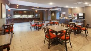 a restaurant with tables and chairs and a bar at Best Western PLUS Austin Airport Inn & Suites in Austin