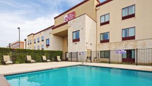 a hotel with a swimming pool in front of a building at Best Western PLUS Austin Airport Inn & Suites in Austin