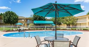 a table with an umbrella next to a pool at Best Western Battlefield Inn in Manassas
