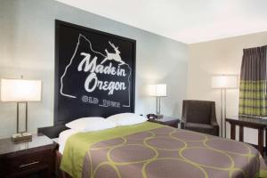 a hotel room with a bed with a sign on the wall at Gateway Inn & Suites Eugene-Springfield in Eugene