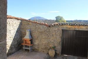 a stone building with a door and a bird feeder at Casa Rural Abuela Luci 