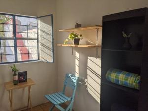 a room with a blue chair and a window at Hostal Casa Colores Adults Only in Guadalajara