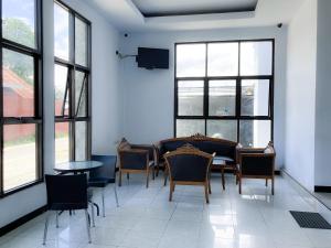 a dining room with a table and chairs and windows at Wisma 88 in Gorontalo