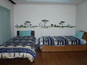 1 dormitorio con 2 camas y una pared con árboles en Mike's B&B Tokoname, en Tokoname