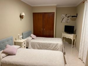 a hospital room with two beds and a television at Hostal Restaurante Puerto Blanco in El Garrobo