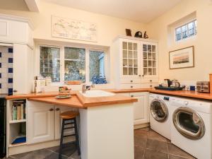 a kitchen with a sink and a washing machine at Old Gaol Cottage in Cerne Abbas