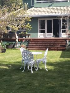 two chairs and a table in front of a house at Amberly House Rotorua in Rotorua