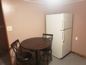 een tafel en stoelen en een koelkast in de kamer bij Relaxing Stay in the Country Unit 1 in Ozark