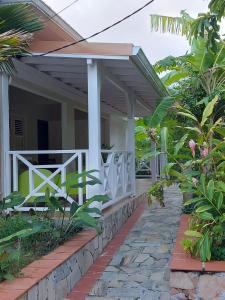 ein Haus mit einer weißen Veranda und einem Steingang in der Unterkunft KAZLETANG in Le Poteau