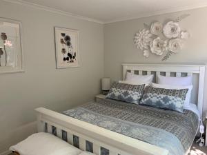 a bedroom with a bed with blue and white pillows at Twin Oaks Quiet Cottage in Paraparaumu