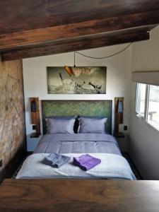a bedroom with a bed with purple towels on it at CASA FARO ARTE in Potrerillos