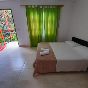 1 dormitorio con 1 cama con cortina verde en Nirvana House Calima Darien, en Calima