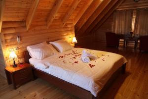 a bedroom with a bed with rose petals on it at Be-Taam Ahava Suites in Bruchim Qela' Alon