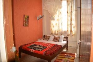 - une petite chambre avec un lit et une fenêtre dans l'établissement Mona Lisa Guest House, Kisumu, à Kisumu