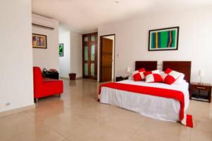 a bedroom with a large bed and a red chair at AW Hotel Chipichape Urban in Cali