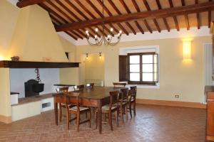 uma sala de jantar com uma mesa de madeira e cadeiras em Cordella in Montalcino Wine Resort em Montalcino