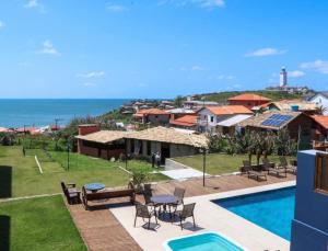 a villa with a swimming pool and a resort at Loft 207 com vista para a piscina e Farol in Laguna