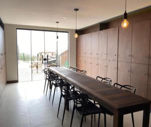 a long wooden table and chairs in a room at Loft 207 com vista para a piscina e Farol in Laguna