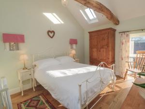 a bedroom with a white bed and two chairs at Wood Cottage in Middlesbrough