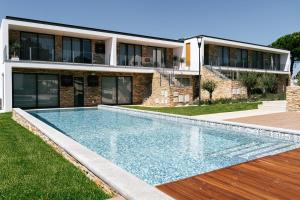 a house with a swimming pool in front of a house at ALTO DA GARÇA - PRIME VILLAS & SPA in Nadadouro