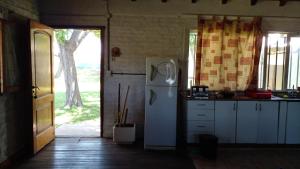 a kitchen with a white refrigerator and a window at Los Arboles, casa completa a 5 minutos del Aeropuerto Ezeiza in Ezeiza