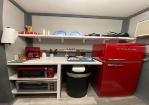 Il comprend une cuisine équipée d'un réfrigérateur rouge et d'un comptoir blanc. dans l'établissement Dragon City, à Maryville