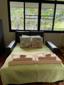 a bedroom with a bed with two towels on it at Khaokhab Lodge in Nong Nam Daeng +42 photos