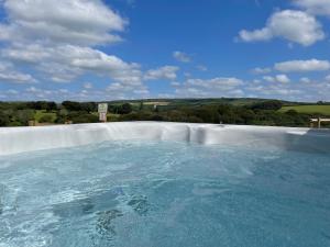 a large swimming pool with blue water in it at Woodhall in Bodmin