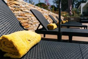 ein gelbes Handtuch auf einem Stuhl auf einer Terrasse in der Unterkunft ALTO DA GARÇA - PRIME VILLAS & SPA in Nadadouro