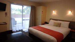 a hotel room with a bed and a large window at Bella Vista Queenstown in Queenstown