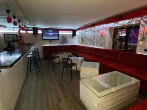 a bar with a red couch and some bar stools at Золотая Ригма in Khabarovsk