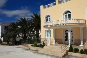 een groot geel huis met een balkon bij Hotel Villaclara in Hospitalet de l'Infant