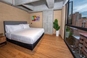 a bedroom with a bed and a large window at Loft 43 in Medellín
