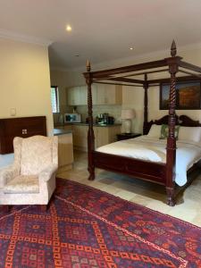 a bedroom with a large canopy bed and a chair at 42onKing in Centurion