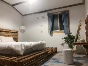 a bedroom with a wooden bed and a window at 綠島海泡泡的家 in Kung-kuan