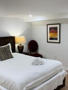 Un dormitorio con una cama blanca con una flor. en Renovated English Basement 2bdrm Home near METRO, en Washington